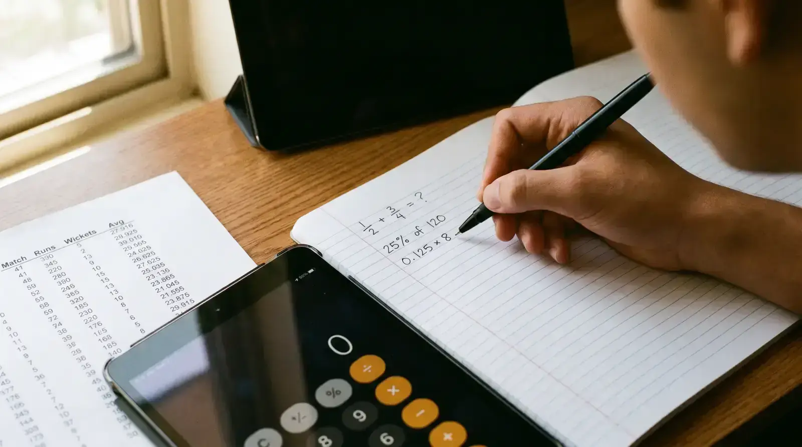 Person writing probability calculations in a notebook with cricket statistics printout nearby