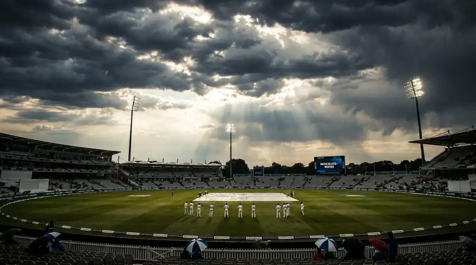 Cricket ground under dramatic changing weather conditions showing cloud formations affecting play